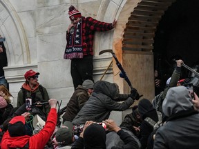Supporters of U.S. President Donald Trump, including a man identified by law enforcement as Michael Joseph Foy brandishing a hockey stick, battle with police at the west entrance of the Capitol during a "Stop the Steal" protest outside of the Capitol building in Washington D.C. Jan. 6, 2021.