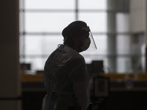 A health worker at the arrivals COVID-19 Testing area at Terminal 1 at Toronto Pearson International Airport on Tuesday Jan. 26, 2021.