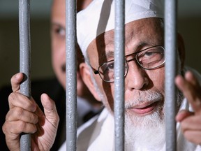 Muslim cleric Abu Bakar Bashir is seen behind bars before his hearing verdict at the South Jakarta District Court on June 16, 2011 in Jakarta, Indonesia.