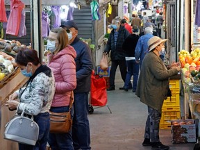 Israelis, wearing protective masks due to the COVID-19 pandemic, shop in the central market of Israel's coastal city of Netanya on Dec. 27, 2020.