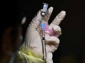 A registered pharmacist technician fills the Pfizer-BioNTech COVID-19 mRNA vaccine at a vaccine clinic during the COVID-19 pandemic in Toronto on Tuesday, December 15, 2020.   THE CANADIAN PRESS/Nathan Denette