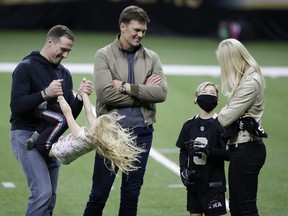New Orleans Saints quarterback Drew Brees, left, plays with his children as Tampa Bay Buccaneers quarterback Tom Brady speaks with Brittany Brees after an NFL divisional round playoff football game between the New Orleans Saints and the Tampa Bay Buccaneers, Sunday, Jan. 17, 2021, in New Orleans.