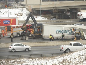 Crews clean up the mess after a transport truck hauling meat crashed in the eastbound express lanes of Highway 401 at Allen Rd. on Tuesday, January 5, 2021.