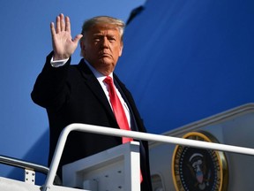 U.S. President Donald Trump waves to the media as he makes his way to board Air Force One before departing from Andrews Air Force Base in Maryland on Jan. 12, 2021.