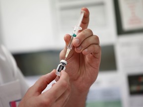 A medical worker draws the Pfizer-BioNTech COVID-19 vaccine from a vial at the Max Fourastier hospital in Nanterre, as the spread of the coronavirus disease continues in France, Jan. 5, 2021.