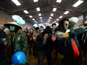 People dance during a party near a disused hangar in Lieuron about 40 km south of Rennes, France, Friday, Jan. 1, 2021.