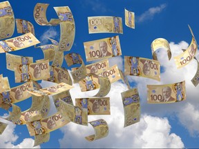 Canadian $100 bills are seen flying in the air in this photo illustration.