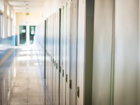 Empty hallway corridor of a high school or college closed during COVID-19 (Coronavirus). Lockers blurred into lonely hallway.