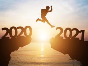 Silhouette man jump from 2020 to 2021 on cliff with sunlight for change and welcome the new year.