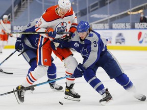 Maple Leafs defencemen Justin Holl (right) checks Edmonton Oilers forward Jesse Puljujarvi  during Toronto's 4-3 overtime loss on Saturday at Rogers Place. The Leafs don't play again until Thursday when they host the Vancouver Canucks.
