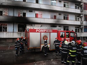 Firemen gather in the courtyard of the Matei Bals infectious diseases hospital's  burned pavilion in Bucharest on January 29, 2021.