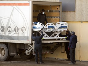 Crews unload hospital beds for the temporary COVID-19 field hospital being set up at the University of Alberta Butterdome, in Edmonton Tuesday Jan. 5, 2021.