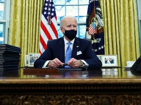 U.S. President Joe Biden signs executive orders in the Oval Office of the White House in Washington, after his inauguration as the 46th President of the United States, Jan. 20, 2021.