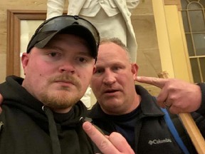 Jacob Fracker and Thomas Robertson, off-duty Rocky Mount, Virginia police officers, gesture in a selfie during the storming of the U.S. Capitol in Washington, January 6, 2021.