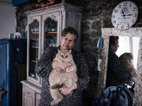 Jeanne Pouchain who, since November 2017, has been declared dead by the French justice system, poses with her cat on Jan. 8, 2021, in Saint-Joseph, France.