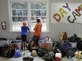 Children try to chat with friends through a window during day camp at YMCA Camp Letts.