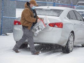 A police officer leaves the rear of the Beef Baron with bagged evidence in London on Tuesday January 26, 2021. (Derek Ruttan/The London Free Press)