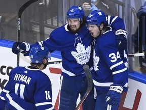 Auston Matthews (34) celebrates a goal with Justin Holl (3) and Zach Hyman during the play-in round against the Columbus Blue Jackets in August.