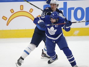 Jets’ Mark Scheifele checks Maple Leafs’ John Tavares during the first period in Toronto on Monday.