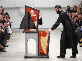 A magician performs with a model who presents a creation by Indian designer Manish Arora as part of his Fall-Winter 2011/2012 women's ready-to-wear fashion collection during Paris Fashion Week March 3, 2011.
