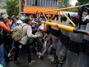 Hondurans taking part in a new caravan of migrants set to head to the United States, try to cross the border, in El Florido, Guatemala January 16, 2021.