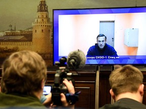 Opposition leader Alexei Navalny appears on a screen set up at a hall of the Moscow Regional Court via a video link in Krasnogorsk outside Moscow on January 28, 2021.