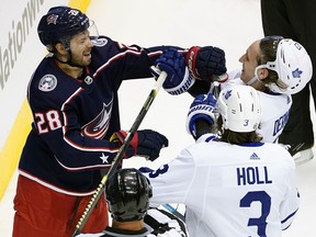 Oliver Bjorkstrand, left, of the Columbus Blue Jackets and Travis Dermott of the Toronto Maple Leafs mix it up during the first period in Game 3 of the Eastern Conference Qualification Round prior to the 2020 NHL Stanley Cup Playoffs at Scotiabank Arena on Aug. 6, 2020 in Toronto.