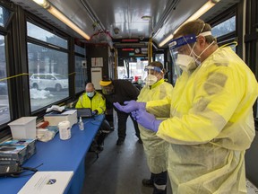 oronto Paramedics prepare the Mobile COVID-19 TTC testing bus at a stop in Toronto.