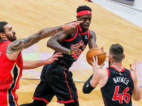 Raptors’ Pascal Siakam (centre) passes to teammate Aron Baynes as Pelicans’ Steven Adams defends on Saturday night in New Orleans.