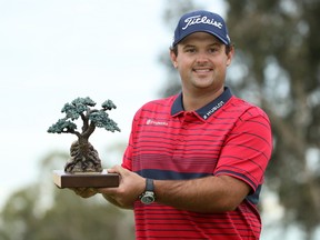 Patrick Reed celebrates with the trophy after winning the Farmers Insurance Open at Torrey Pines South on Jan. 31, 2021 in San Diego, Calif.