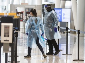 Health workers at the arrivals COVID-19 testing area at Terminal 1 at Toronto Pearson International Airport on January 26, 2021.