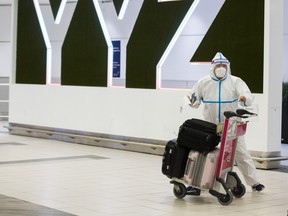 A passenger is covered head to toe at the International Arrivals area in Terminal 3 at Toronto Pearson International Airport on Tuesday, Jan. 26, 2021.