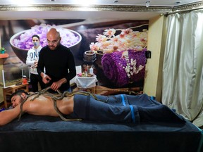 Spa owner Safwat Sedki gives a non-venomous snakes thirty-minute massage treatment to a customer at his shop in Cairo, Egypt.