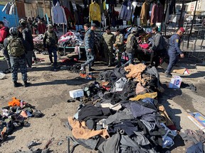 Members of Iraqi security forces inspect the site of a suicide attack in a central market in Baghdad, Iraq January 21, 2021.