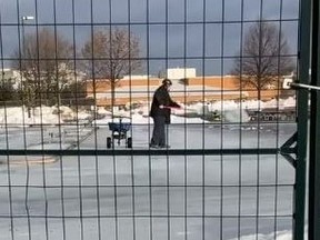 A worker spreads salt on an outdoor ice rink behind Garnet A. Williams Community Centre in Thornhill on Saturday, Jan. 16 2021.