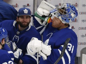 Toronto Maple Leafs goaltender Jack Campbell is on the bench while teammate Frederik Andersen gets a beverage during a break in the action during the first period on Jan. 18, 2021.