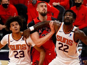 Raptors big man Alex Len, shown battling with two Phoenix Suns players on Jan. 6, 2021, was used as the team’s starting centre against Sacramento on Jan. 8, 2021.