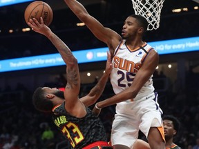 Suns forward Mikal Bridges (25) blocks a shot attempt by Hawks guard Allen Crabbe (33) during NBA action at State Farm Arena in Atlanta, Jan. 14, 2020.
