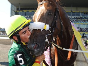 Now retired jockey Eurico Rosa Da Silva kisses Big Red Mike after capturing the 151 st running at Woodbine Racetrack.