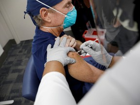 A medical staff member receives the Pfizer-BioNTech COVID-19 Vaccine at Jackson Memorial Hospital in Miami, Florida, U.S., December 15, 2020.