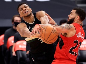 Giannis Antetokounmpo (left) of the Milwaukee Bucks and Fred VanVleet of the Toronto Raptors fight for the ball on Wednesday night at Amalie Arena.