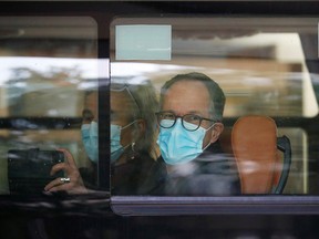 Members of the World Health Organization (WHO) team tasked with investigating the origins of the coronavirus pandemic sit on a bus as they leave their quarantine hotel in Wuhan, China January 28, 2021.