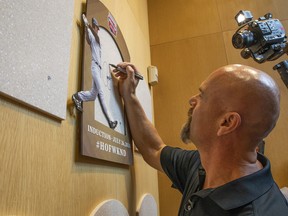 Larry Walker signs where his plaque will hang when he is inducted into the Baseball Hall of Fame.