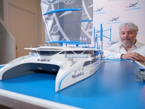 Franco-Swiss skipper and founder of 'The SeaCleaners' NGO, Yvan Bourgnon, poses next to a model of the 'Manta,' a giant sailing boat which will collect and recycle the oceans' floating plastic waste, in Paris, Jan. 26, 2021.
