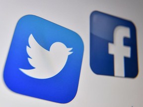 In this file photo taken on October 29, 2020 a photo taken on October 21, 2020 shows the logo of the the American online social media and social networking service, Facebook and Twitter.