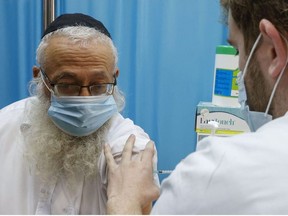 A healthcare worker administers a COVID-19 vaccine at Clalit Health Services, in the ultra-Orthodox Israeli city of Bnei Brak, on January 6, 2021.