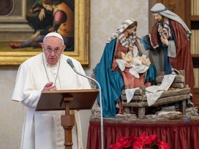 This photo taken on January 10, 2021 and handout on January 11, 2021 by the Vatican Media shows Pope Francis holding a weekly live streamed Angelus prayer by a Nativity Scene, from the library of the apostolic palace in The Vatican, during the COVID-19 pandemic caused by the novel coronavirus.