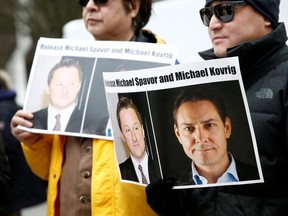 People hold signs calling for China to release Canadian detainees Michael Spavor and Michael Kovrig, in Vancouver, March 6, 2019.