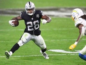Las Vegas Raiders running back Josh Jacobs runs the ball against Los Angeles Chargers strong safety Rayshawn Jenkins during overtime at Allegiant Stadium.