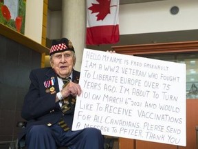 Der Veteran des Zweiten Weltkriegs, Fred Arsenault, hält ein Schild hoch, in dem er Pfizer auffordert, die Kanadier zu seinem 101. Geburtstag mit genügend Impfstoffen zu versorgen.